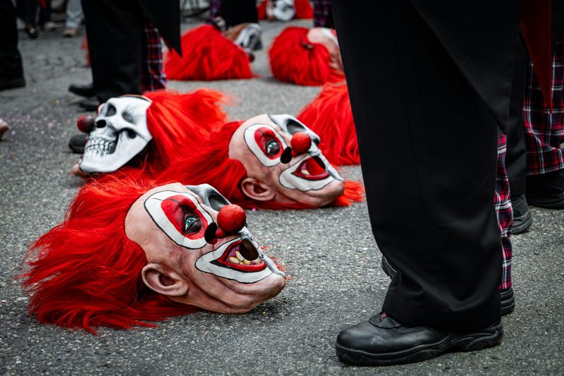 Fasnacht masks with red hair resting on the cobbles.