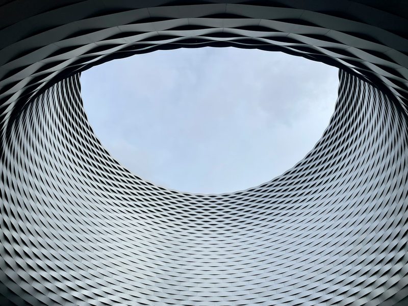 The round opening in the roof of Messe Basel framing the sky.