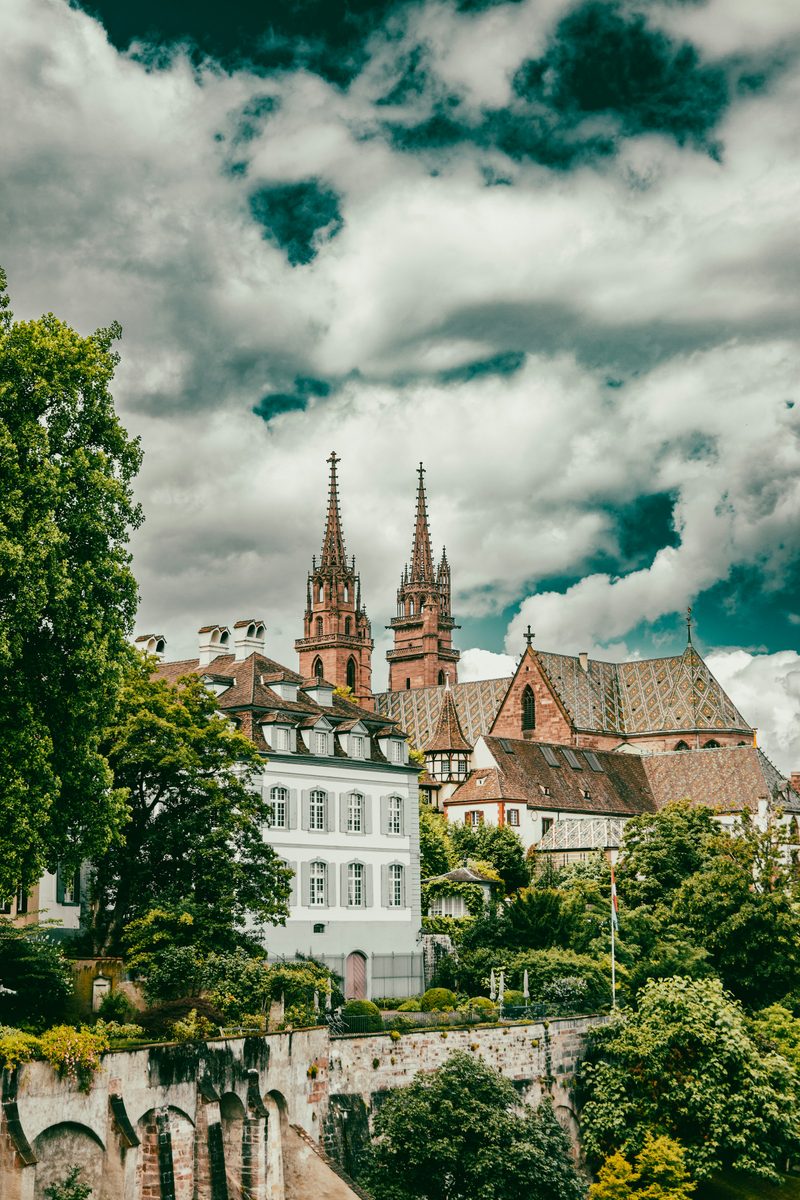 The twin red sandstone towers of Basel Münster above Old Town rooftops.
